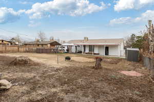 Rear view of property with a storage shed and an outdoor fire pit