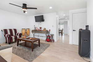 Living room with ceiling fan and light wood-type flooring