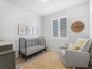 Carpeted bedroom featuring a crib