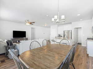 Dining room featuring dark hardwood / wood-style flooring and ceiling fan with notable chandelier