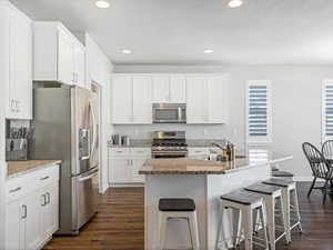 Kitchen featuring sink, white cabinets, and appliances with stainless steel finishes