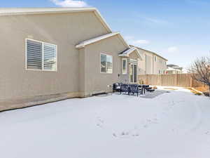 View of snow covered back of property