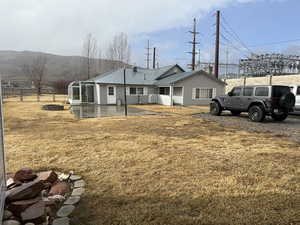 Exterior space with a mountain view, a front lawn, and a patio area