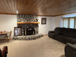 Carpeted living room with ornamental molding and wood ceiling