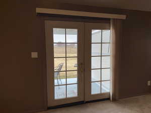 Doorway featuring light carpet and french doors