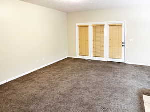 Unfurnished room with dark colored carpet