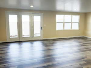 Unfurnished living room featuring recessed lighting, baseboards, and dark wood-type flooring