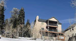 rear of property featuring two covered decks and a patio