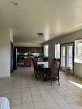 Dining area featuring a textured ceiling and light tile patterned floors