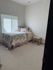 Bedroom with light colored carpet and baseboards
