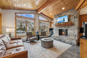 Living room with wood ceiling, a fireplace, high vaulted ceiling, and beamed ceiling