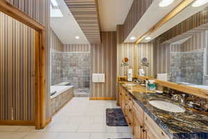 Bathroom featuring vanity, tile patterned flooring, and plus walk in shower