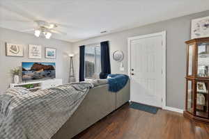 Living room with dark hardwood / wood-style floors and ceiling fan