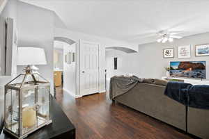 Living room with ceiling fan, dark hardwood / wood-style flooring, and sink