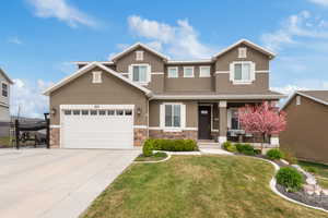 Craftsman inspired home with driveway, stone siding, stucco siding, and fence