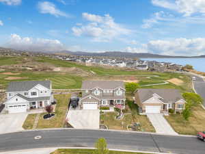 Drone / aerial view featuring golf course view, a residential view, and a water and mountain view