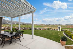 View of patio featuring a pergola, outdoor dining space, and a mountain view