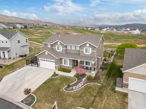 Traditional home with concrete driveway, a residential view, stone siding, stucco siding, and a porch