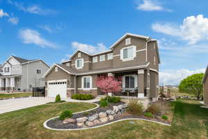 Craftsman-style house featuring stucco siding, a porch, and a front lawn