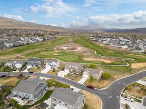 Drone / aerial view of front of home with a mountain view, a residential view, and view of golf course