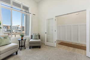 Sitting room with light colored carpet and a high ceiling