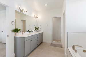 Bathroom with vanity, tile patterned flooring, and separate shower and tub