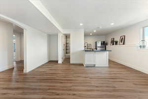 Kitchen with light hardwood / wood-style flooring, stainless steel fridge, and white cabinets