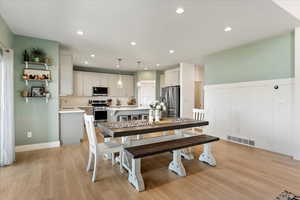 Dining space with sink and light hardwood / wood-style flooring