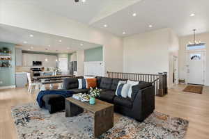 Living room with an inviting chandelier and light hardwood / wood-style flooring