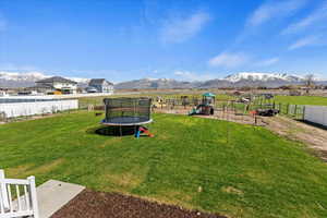 View of yard featuring a playground, a trampoline, and a mountain view