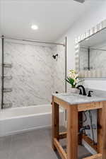 Bathroom featuring tiled shower / bath, vanity, and tile patterned floors