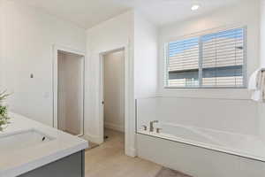 Bathroom featuring vanity, tile patterned flooring, and plus walk in shower