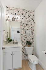 Bathroom featuring hardwood / wood-style flooring, vanity, and toilet