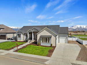 View of front facade with a garage, a mountain view, and a front lawn