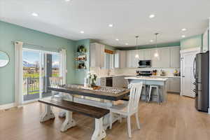 Dining space with sink and light wood-type flooring