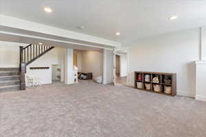 Unfurnished living room featuring carpet and a textured ceiling