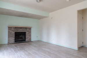 Unfurnished living room featuring a fireplace and light hardwood / wood-style floors