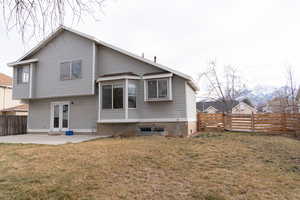 Back of house with a yard and a patio
