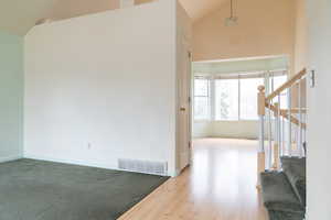 Interior space featuring hardwood / wood-style flooring and high vaulted ceiling