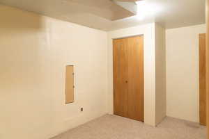 Unfurnished bedroom with light colored carpet and a closet
