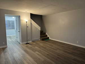 Empty room with hardwood / wood-style flooring and a textured ceiling