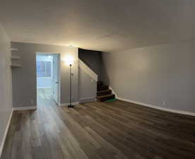 Interior space with dark wood-type flooring and a textured ceiling