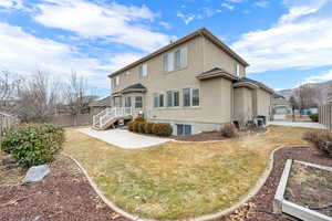 Fully landscaped backyard with a deck and 2 HVAC units