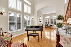 Extra space adjacent to living room featuring a high ceiling and  hardwood flooring