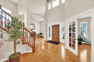 Entryway featuring hardwood flooring and a two story tall ceiling