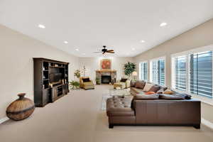 Living room with a stone fireplace and ceiling fan