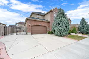 View of front of property featuring a 2-car garage, double rod iron gate and RV pad