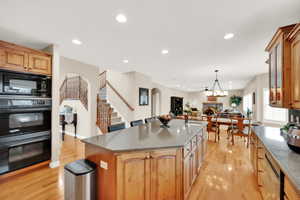 Kitchen features granite counter top, an island, double sink, double oven