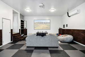 Living room with a wall unit AC and brick wall