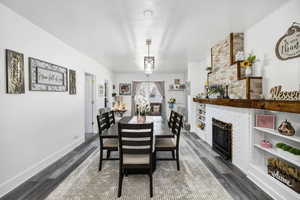 Dining area featuring dark hardwood / wood-style flooring, a fireplace, and a textured ceiling